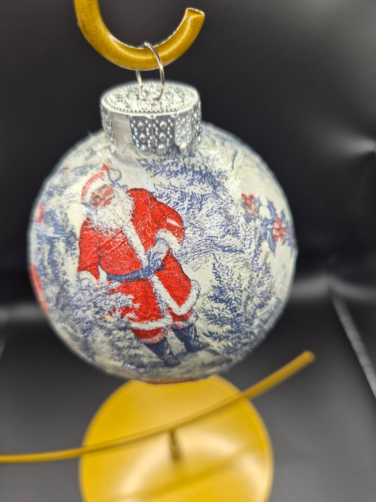 Real photo of the Blue Santa toile ornament on a gold stand